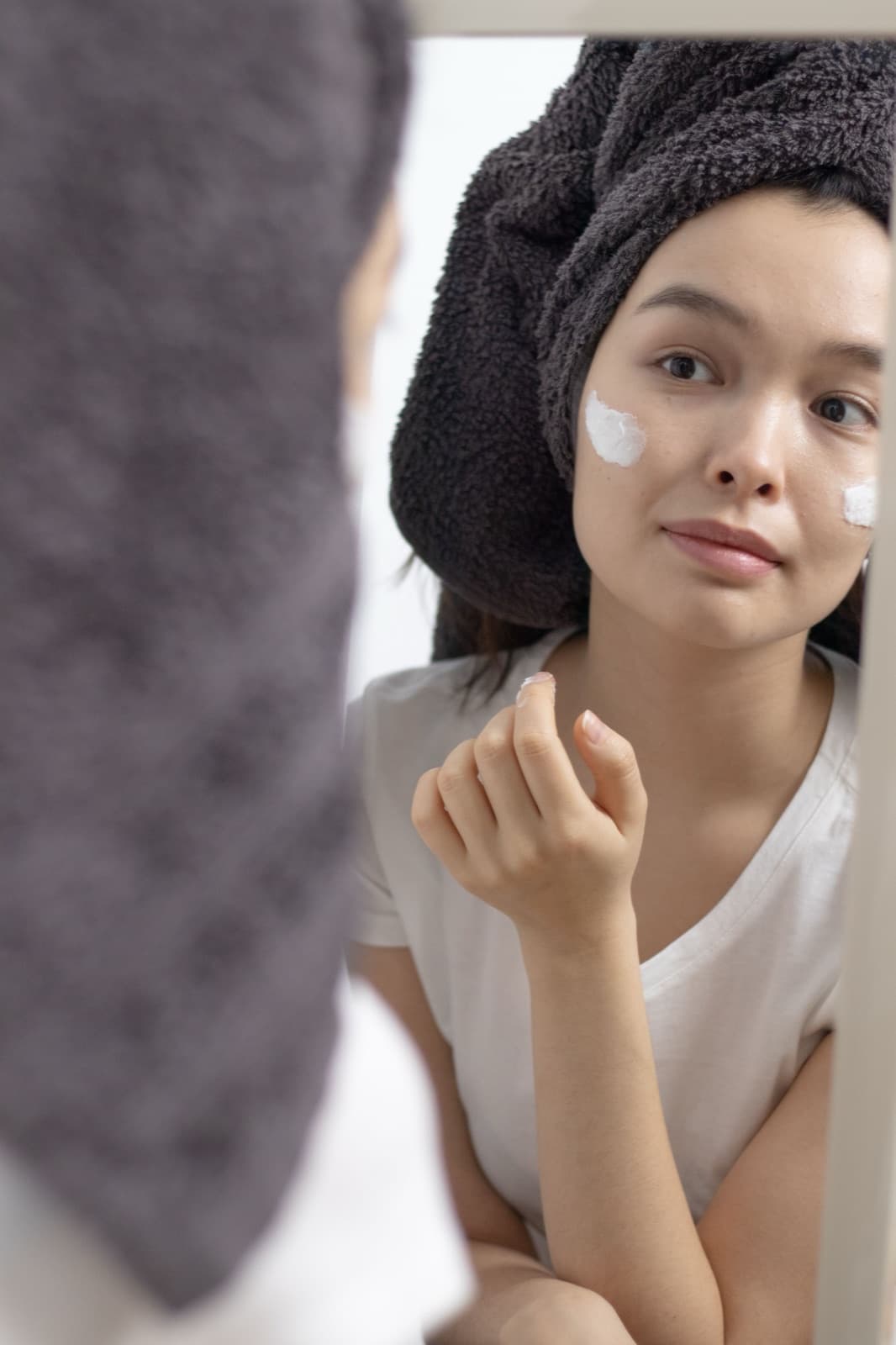 Ohis Beauty founder applying a botanical serum